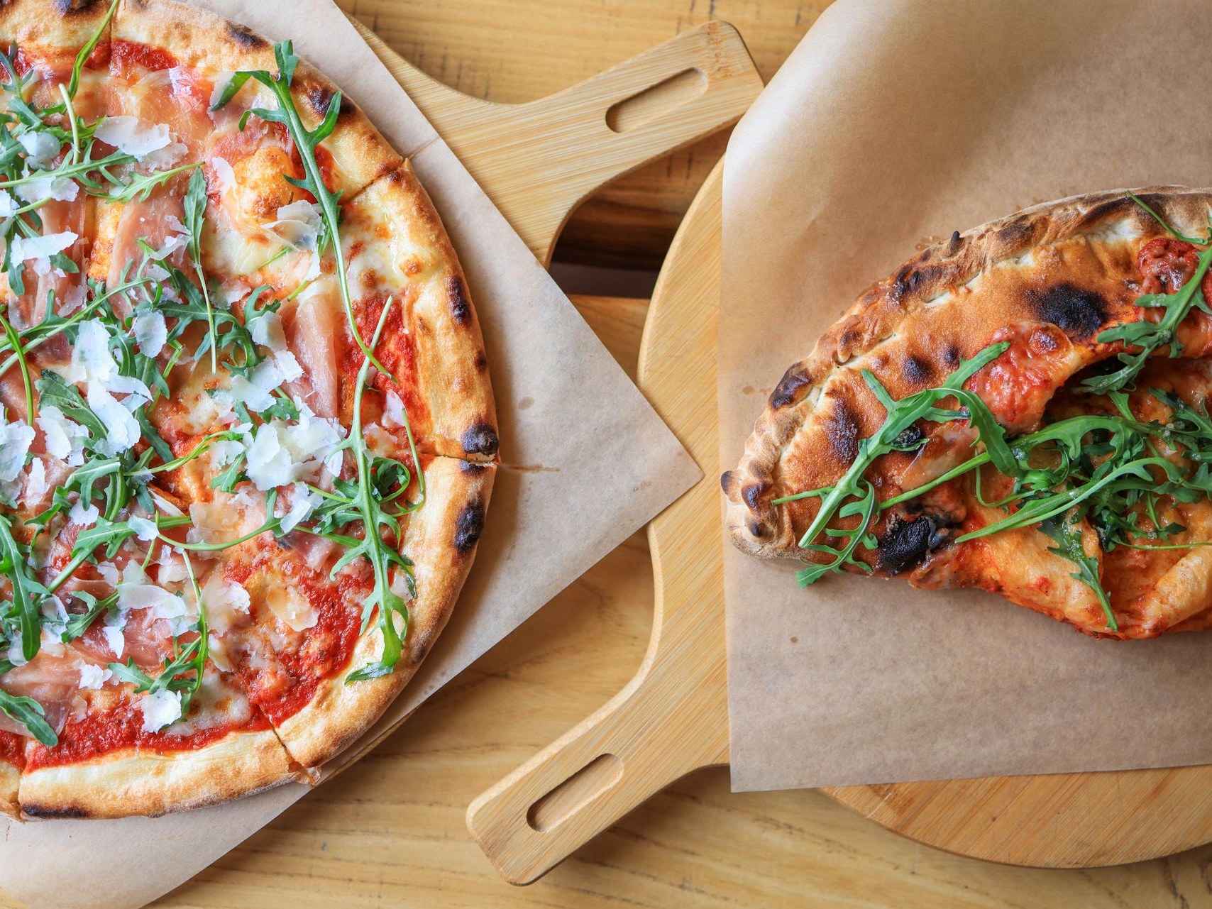 A whole pizza on a wooden peel