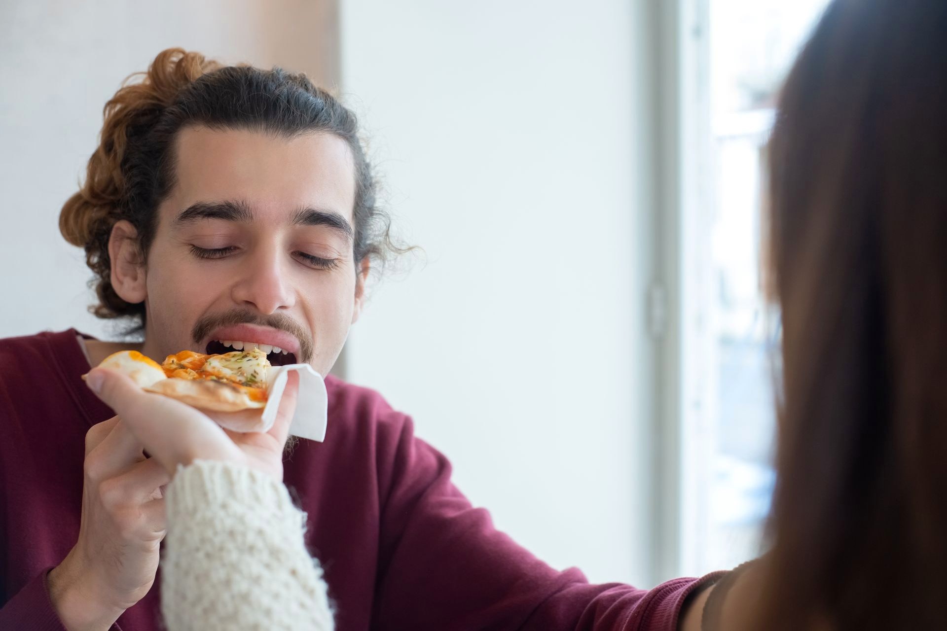 A person eating a slice of pizza