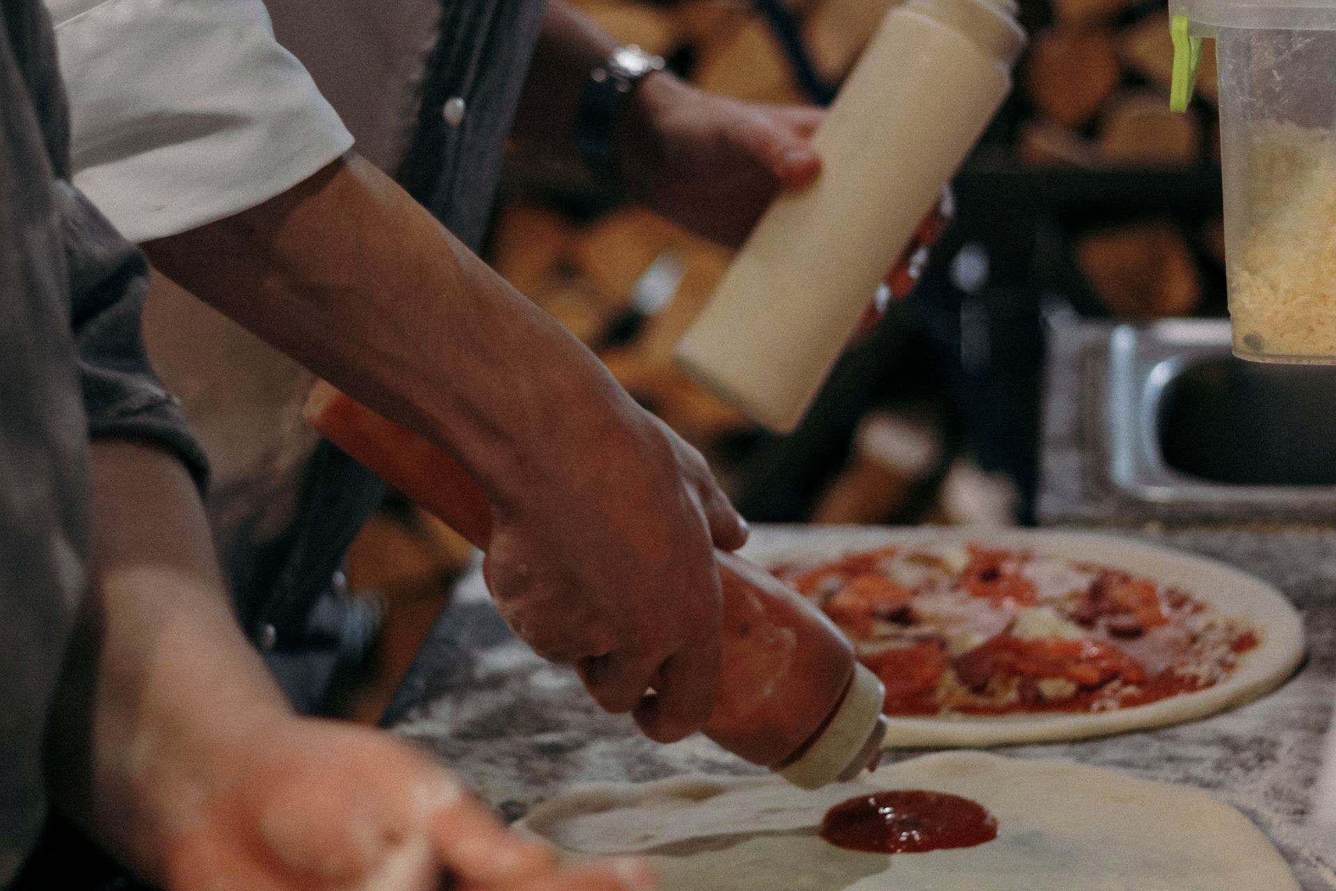 Menu — Pizza A pizza being topped before baking
