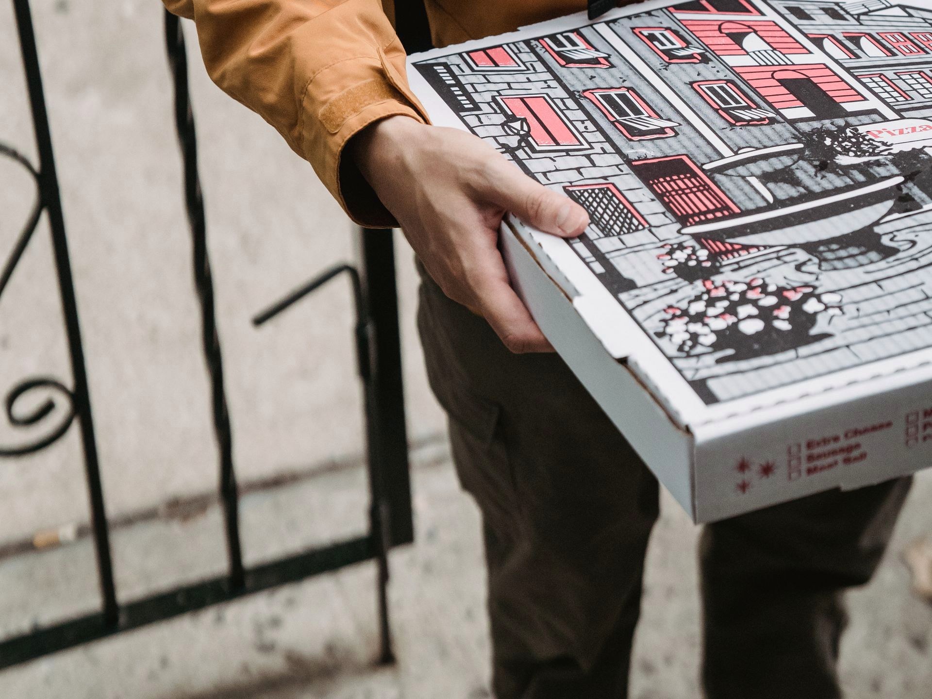 A person carrying a pizza box on the street